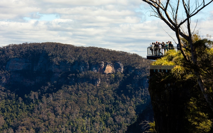 Visitors on a lookout at Echo Point with view of Three Sisters, Blue Mountains, Australia.