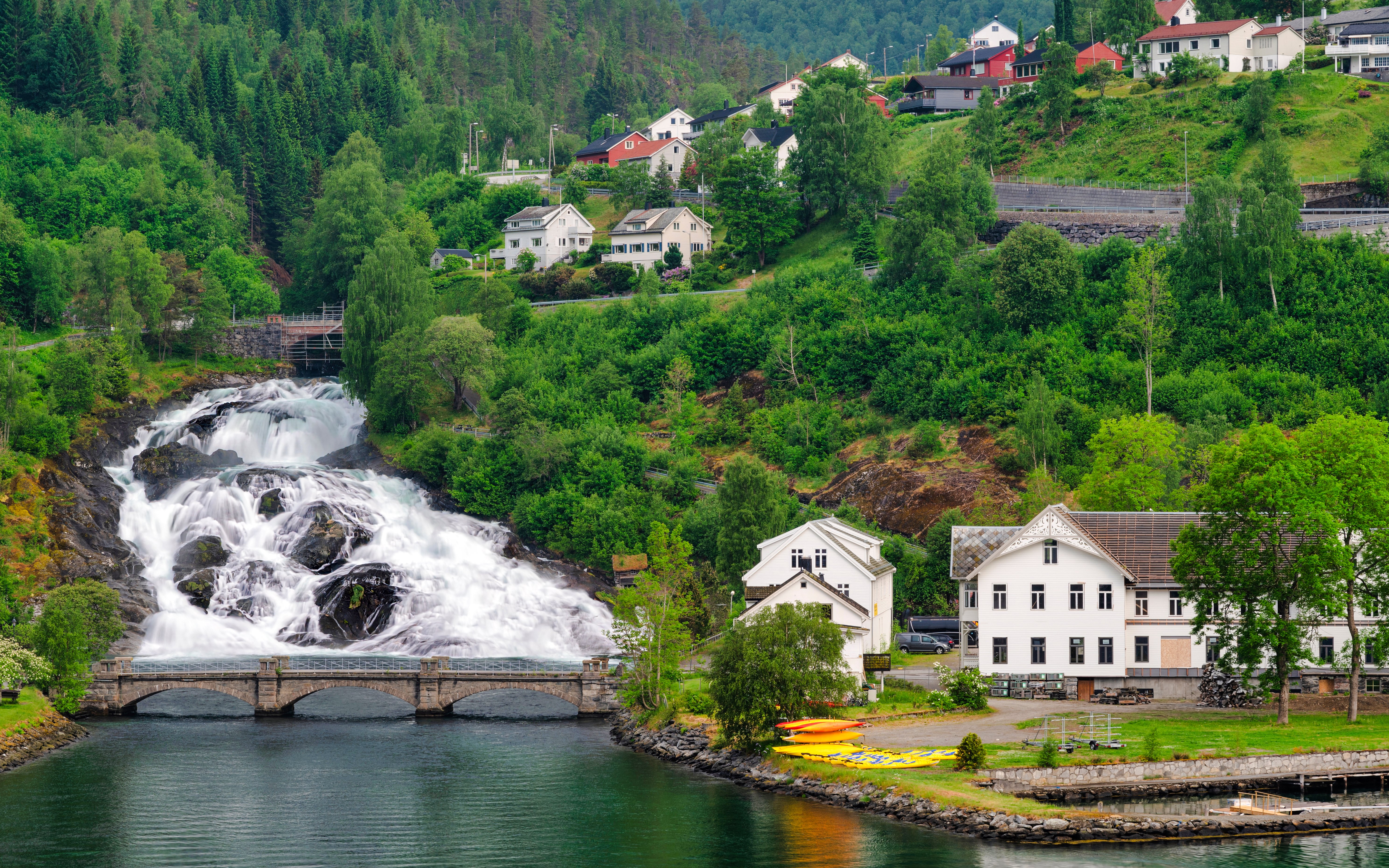 Hellesylt waterfall cascading near village houses in Norway.