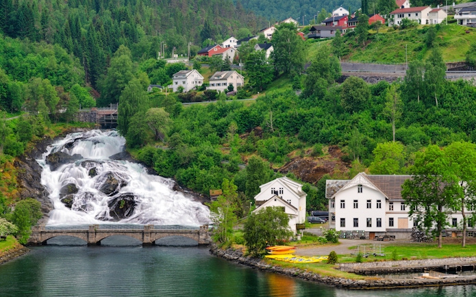 Hellesylt waterfall cascading near village houses in Norway.