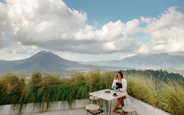 Breakfast on a terrace with Mount Batur in the background, Bali.