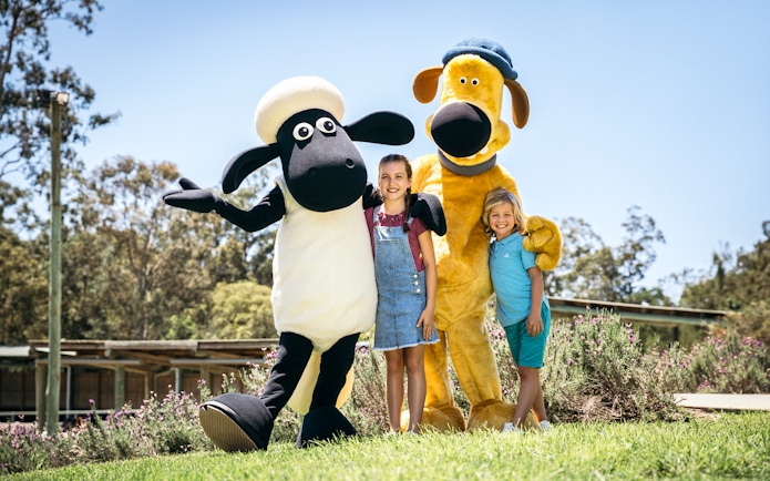 Children posing with animal mascots at Paradise Country.