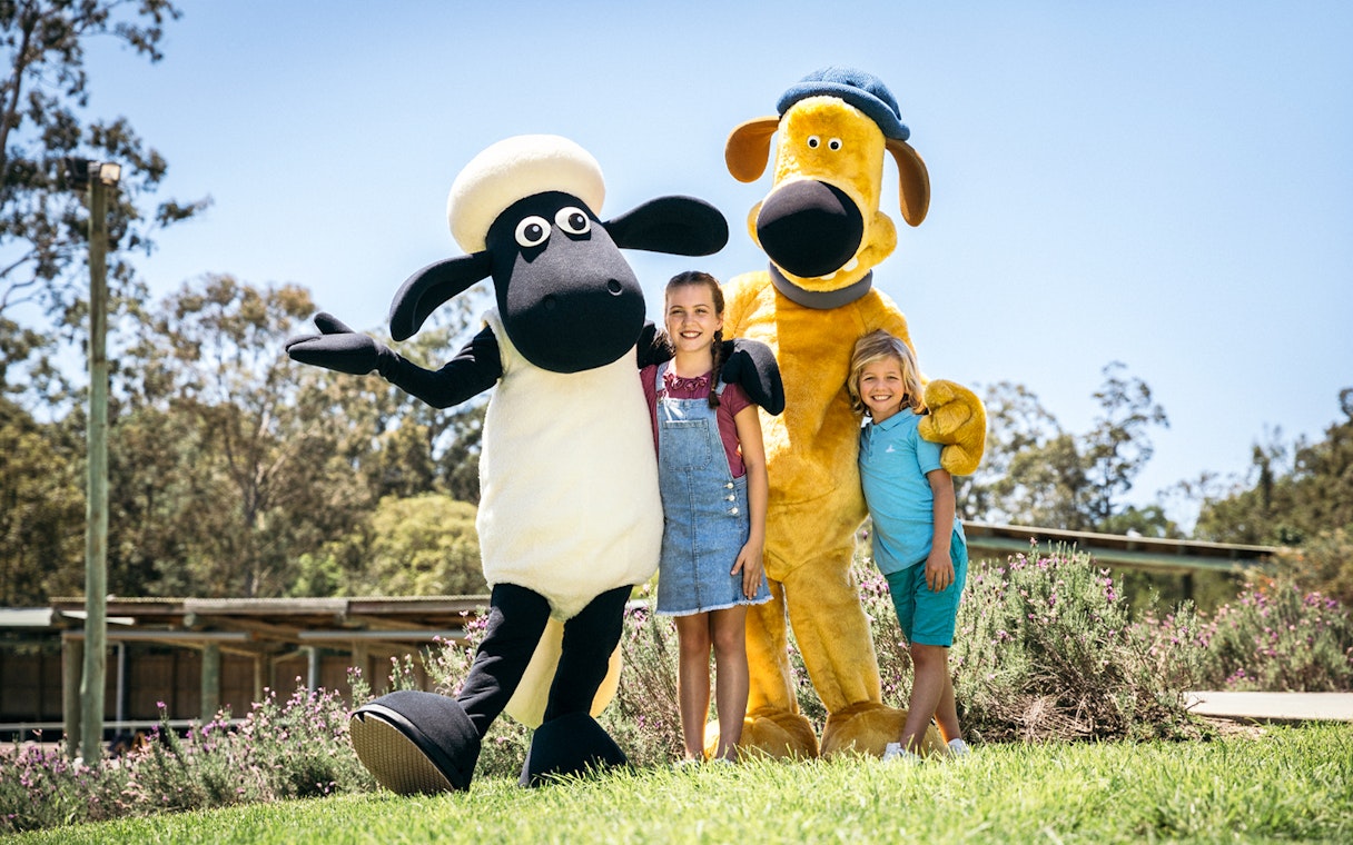 Children posing with animal mascots at Paradise Country.