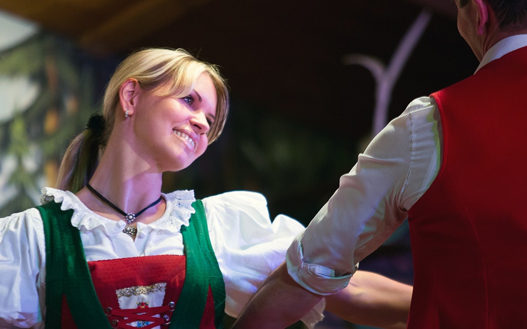 Dancers in traditional Tyrolean attire performing at a folk show.
