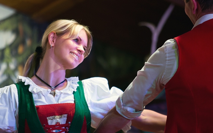 Dancers in traditional Tyrolean attire performing at a folk show.