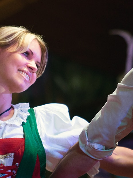 Dancers in traditional Tyrolean attire performing at a folk show.