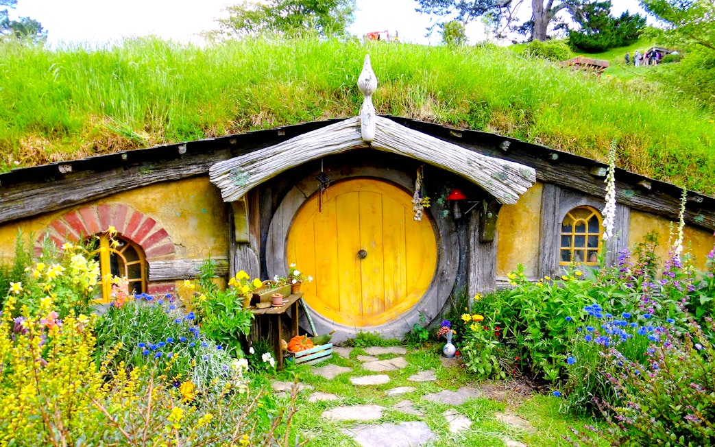 Hobbit house with yellow door and garden at Hobbiton movie set tour.