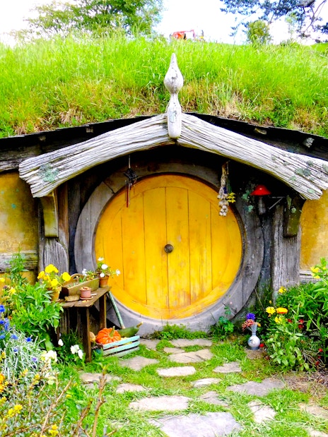 Hobbit house with yellow door and garden at Hobbiton movie set tour.