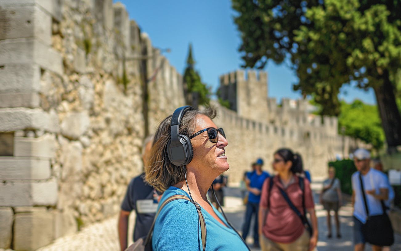 Visitor enjoying audio tour at St. George Castle, Lisbon.