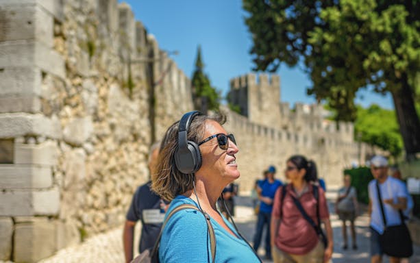Visitor enjoying audio tour at St. George Castle, Lisbon.