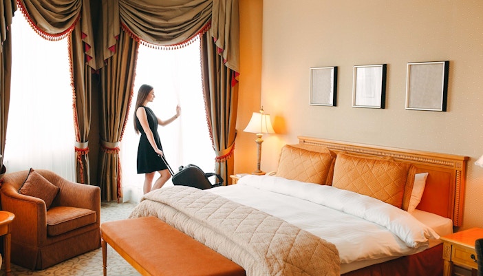 Guest in hotel room with suitcase