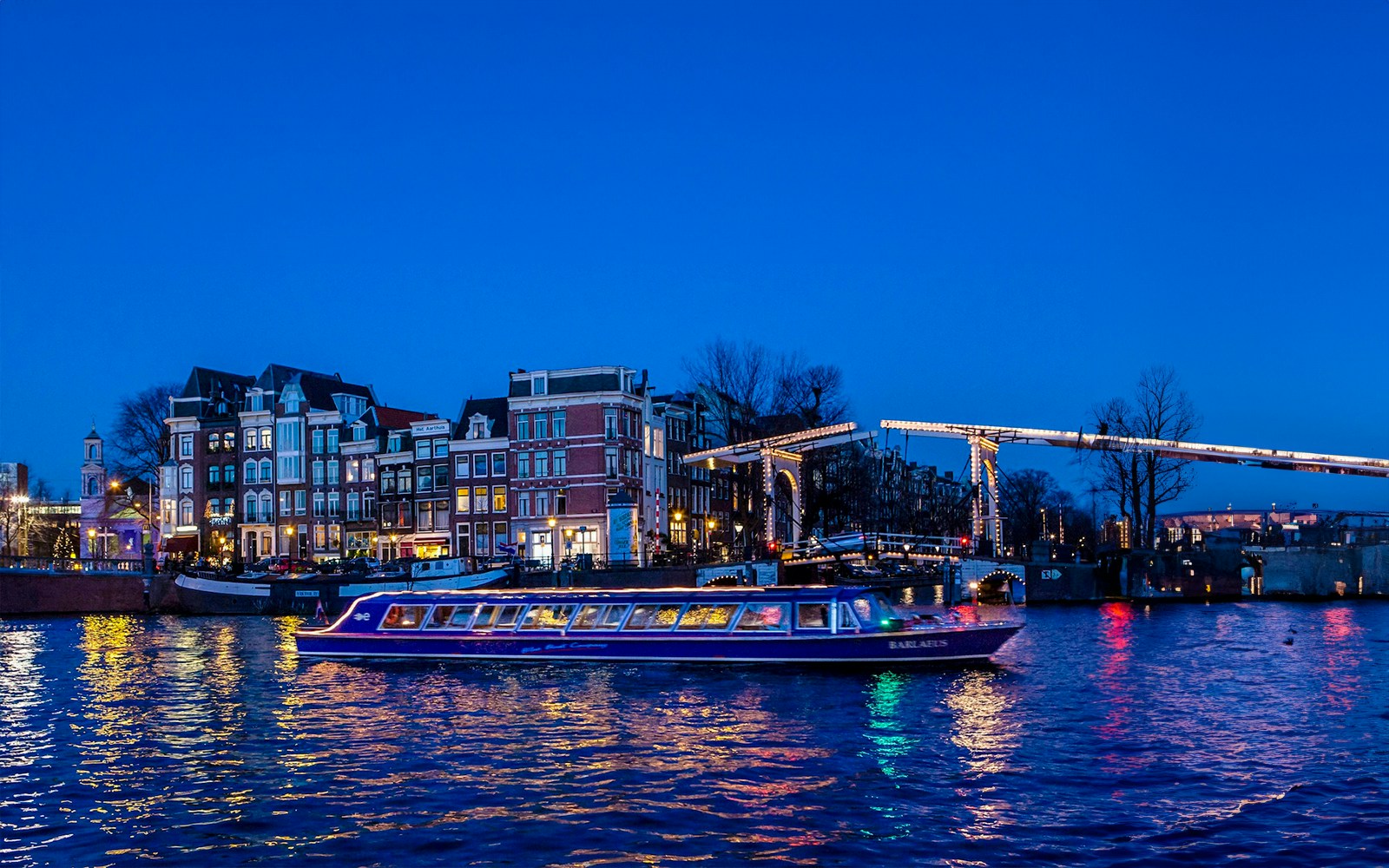 Evening canal cruise boat on Amsterdam's illuminated waterways.