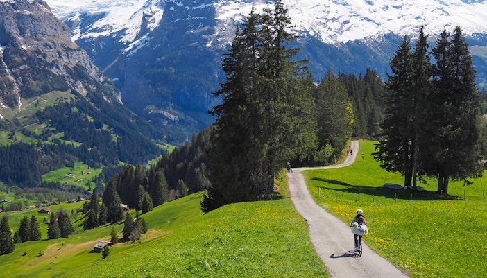 Tourist riding a bike in Grindelwald - June