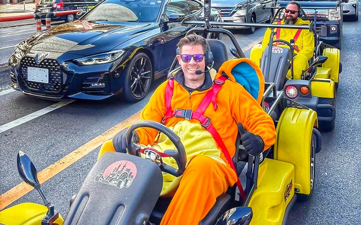 Go-kart riders in costumes on Tokyo street during Skytree, Ginza, and Imperial Palace tour.
