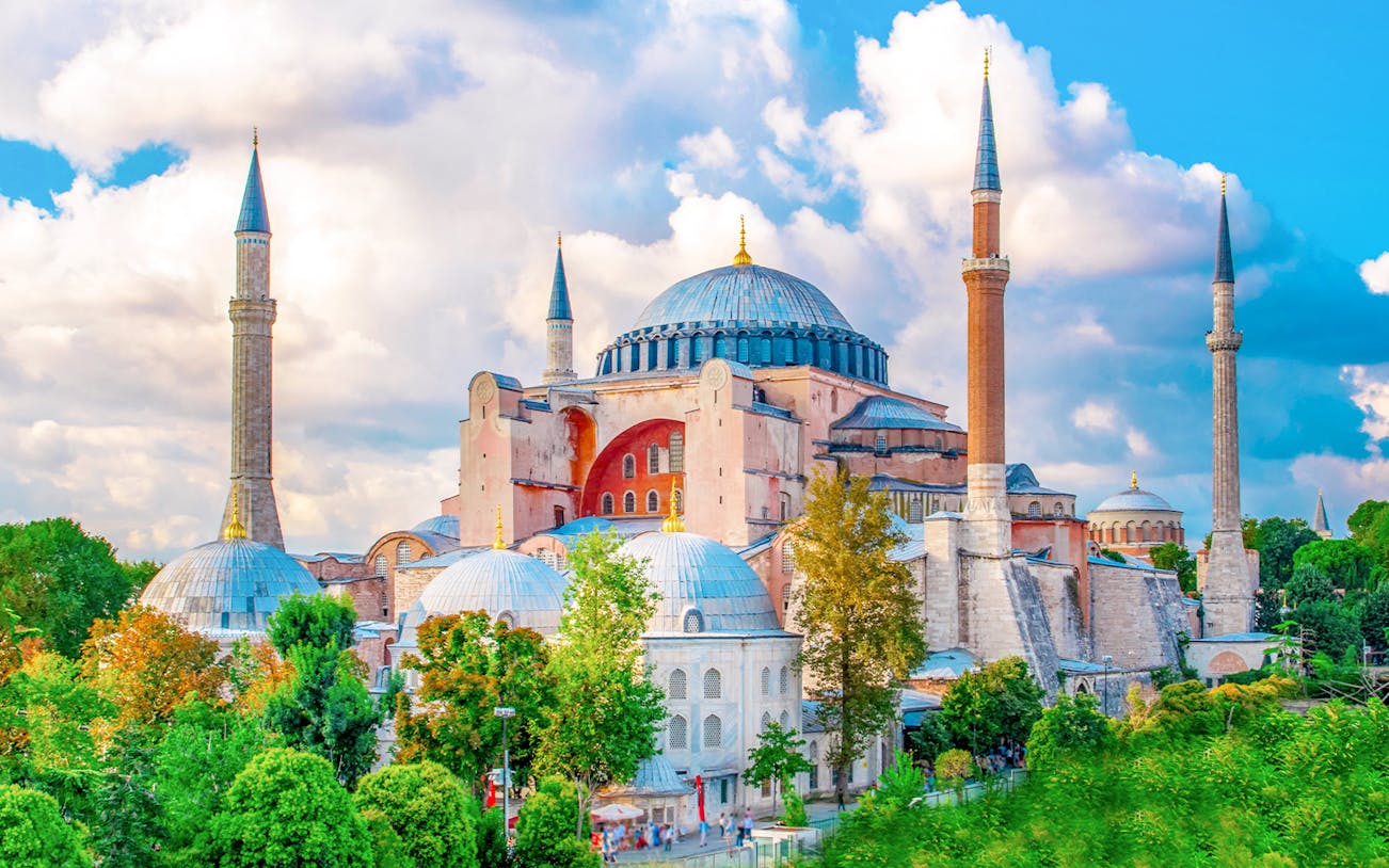 Hagia Sophia exterior with minarets in Istanbul, surrounded by greenery.