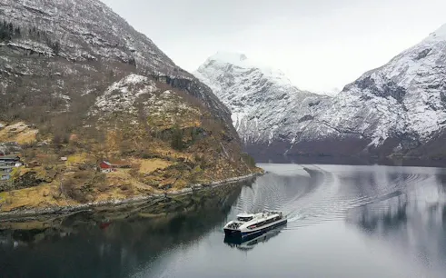Cruise ship on Geirangerfjord with snow-covered mountains, Ålesund to Geiranger route.