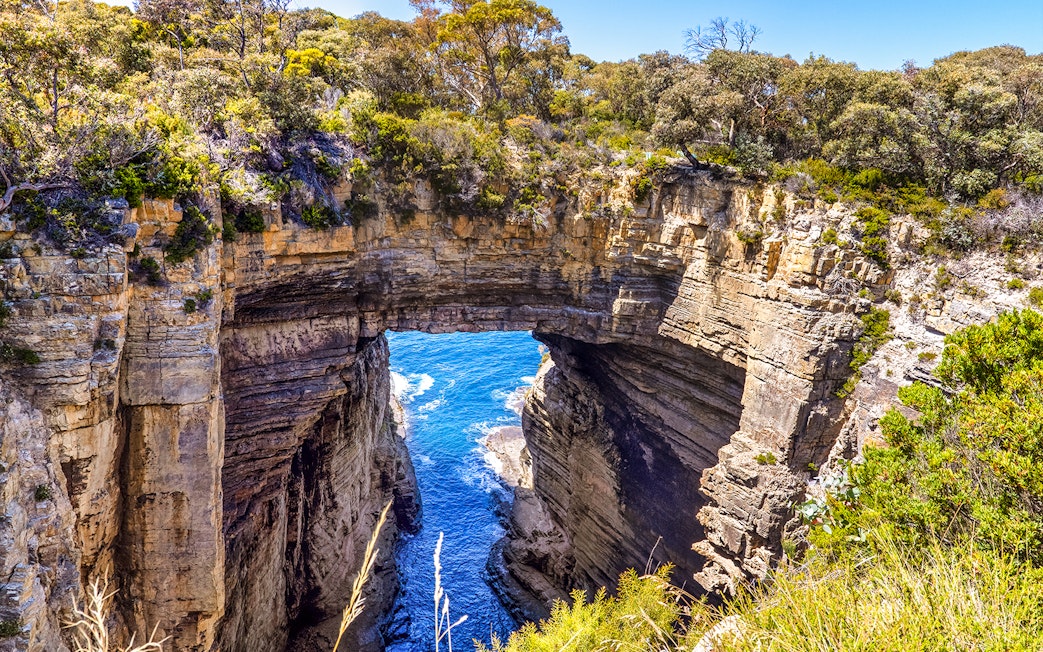 Natural rock arch formation at Tasman National Park, Tasmania, viewed on a guided tour.