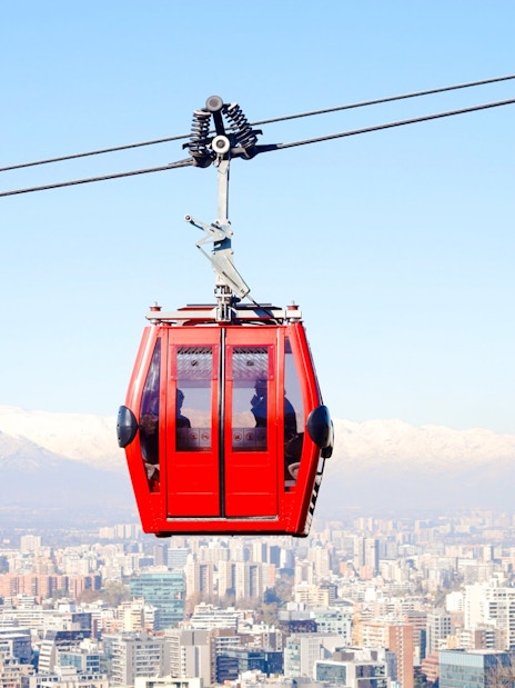 Santiago cable car over cityscape with Andes mountains in the background.
