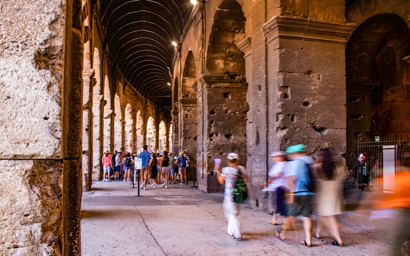 Tourists exploring the interior arches of the Colosseum in Rome, Italy.