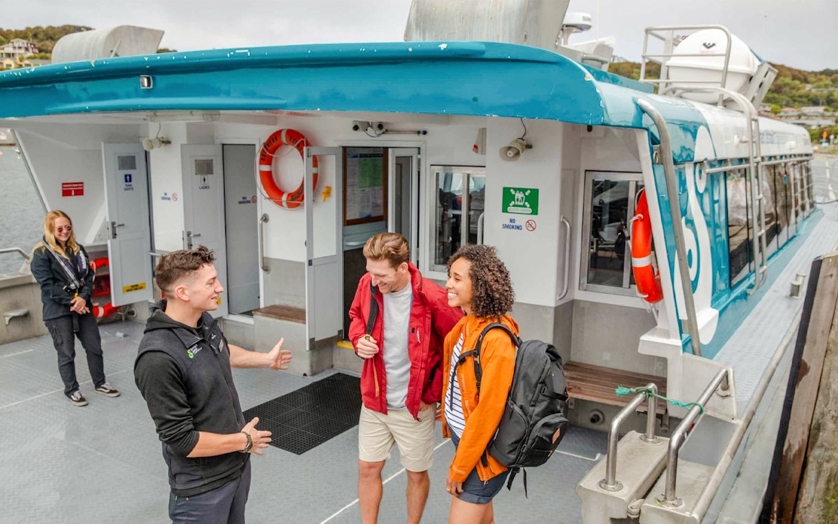 Crew assisting tourists boarding the Stewart Island Ferry.