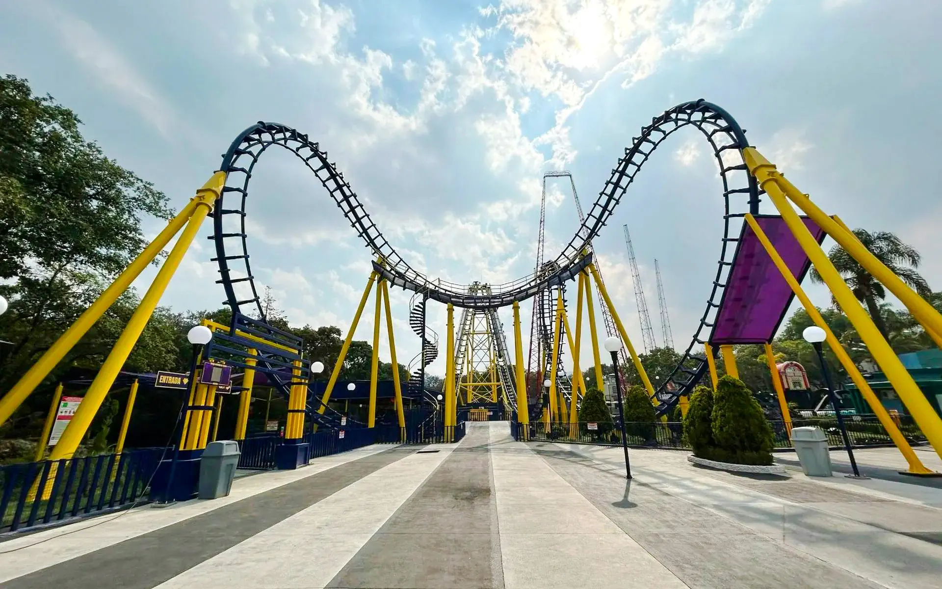 Batgirl roller coaster track at Six Flags Mexico with yellow supports and loops.