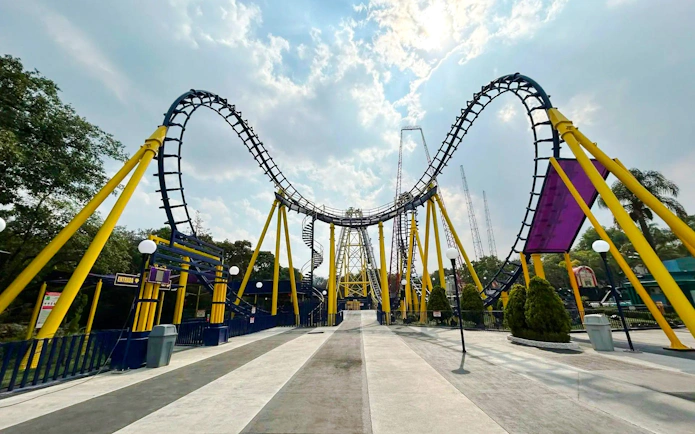 Batgirl roller coaster track at Six Flags Mexico with yellow supports and loops.