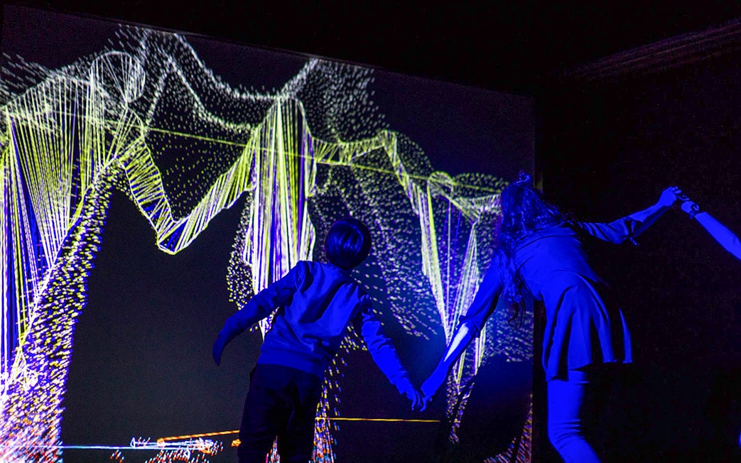 Visitors interacting with light art at Lumia Gallery exhibition.