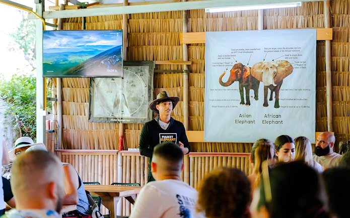 Guide discussing elephants at Phuket Elephant Care with visitors.