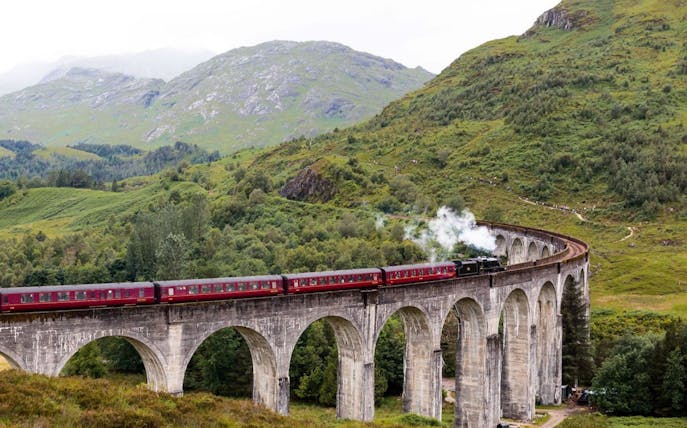 Jacobite Steam Train crossing Glenfinnan Viaduct in the Scottish Highlands.