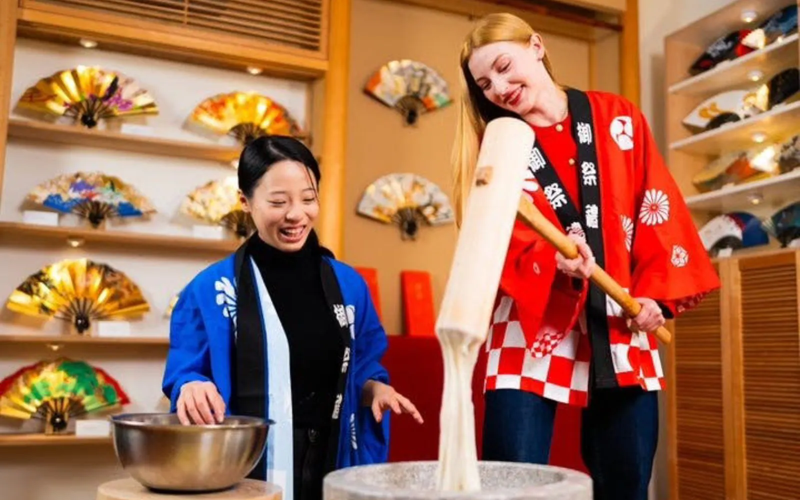 Traditional mochi pounding in Kyoto with participants in colorful attire.