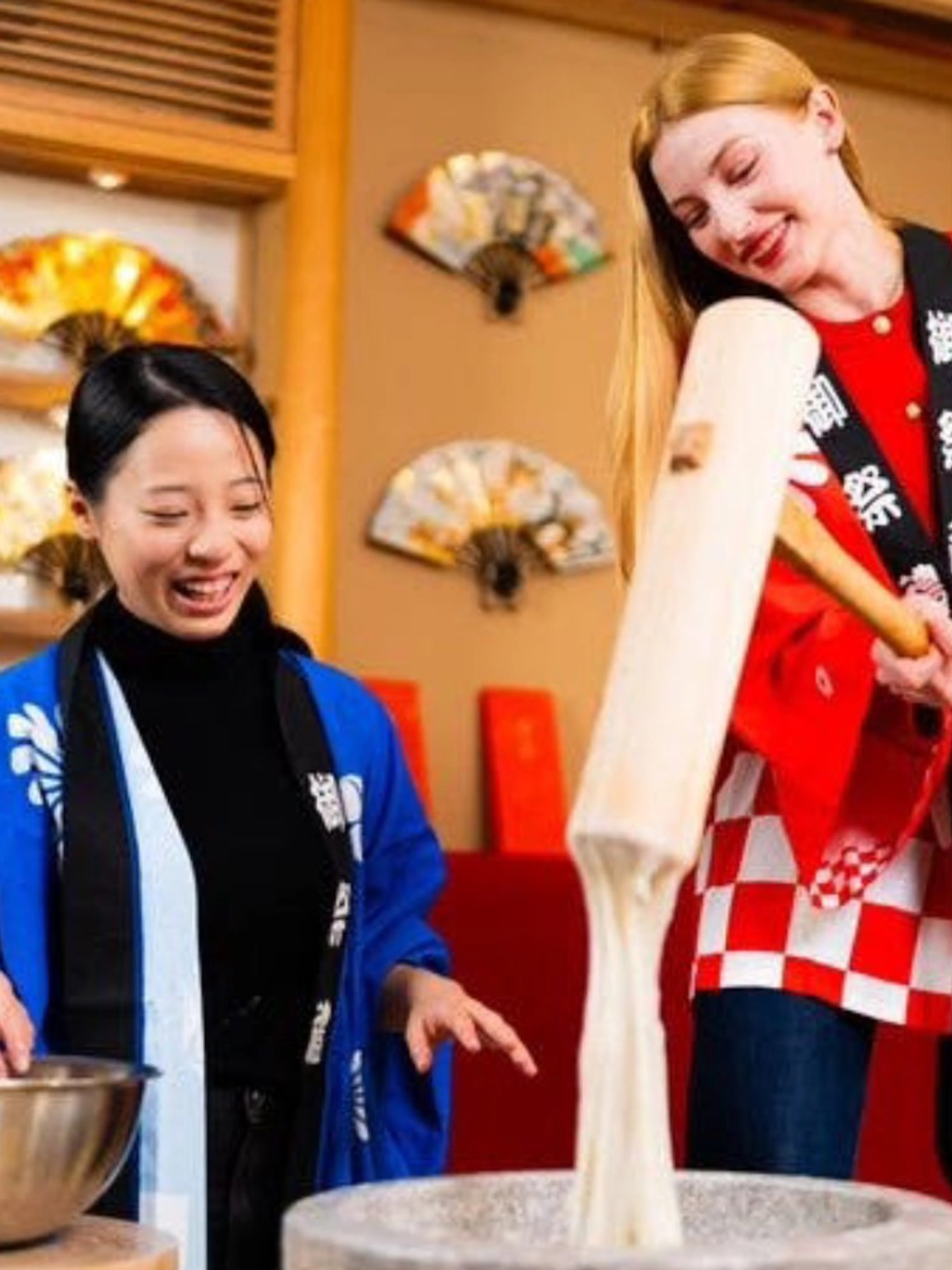 Traditional mochi pounding in Kyoto with participants in colorful attire.
