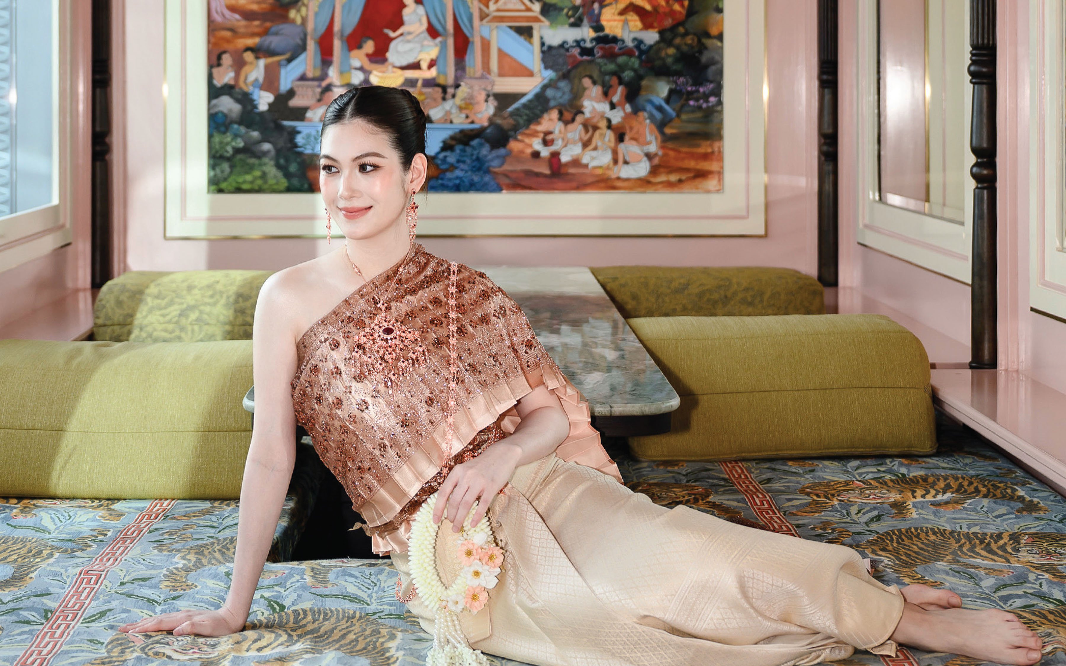 Person in traditional Thai clothing at Aakara Sky with mural backdrop.