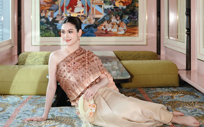 Person in traditional Thai clothing at Aakara Sky with mural backdrop.