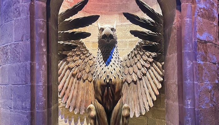 Winged statue in an archway at a themed attraction, related to Fawkes.