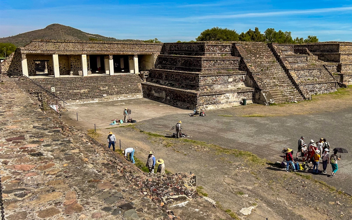 Entrance to the Palace of Quetzalpapalotl with tourists exploring the ancient site.