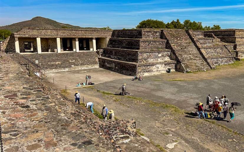 Entrance to the Palace of Quetzalpapalotl with tourists exploring the ancient site.