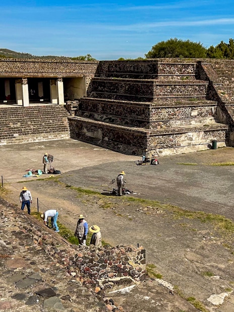 Entrance to the Palace of Quetzalpapalotl with tourists exploring the ancient site.