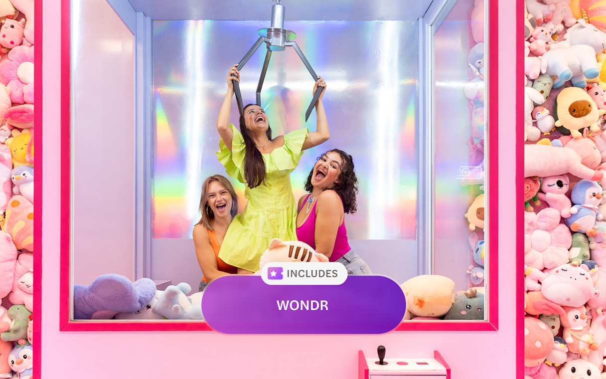 Women enjoying a claw machine experience at WONDR Amsterdam.