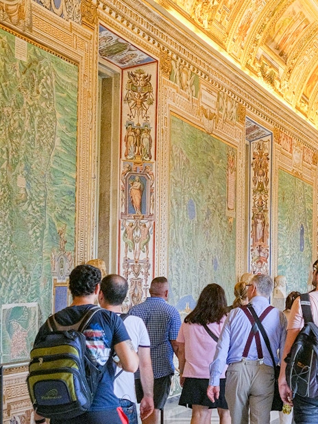 Visitors exploring the ornate Gallery of Maps in the Vatican Museums.