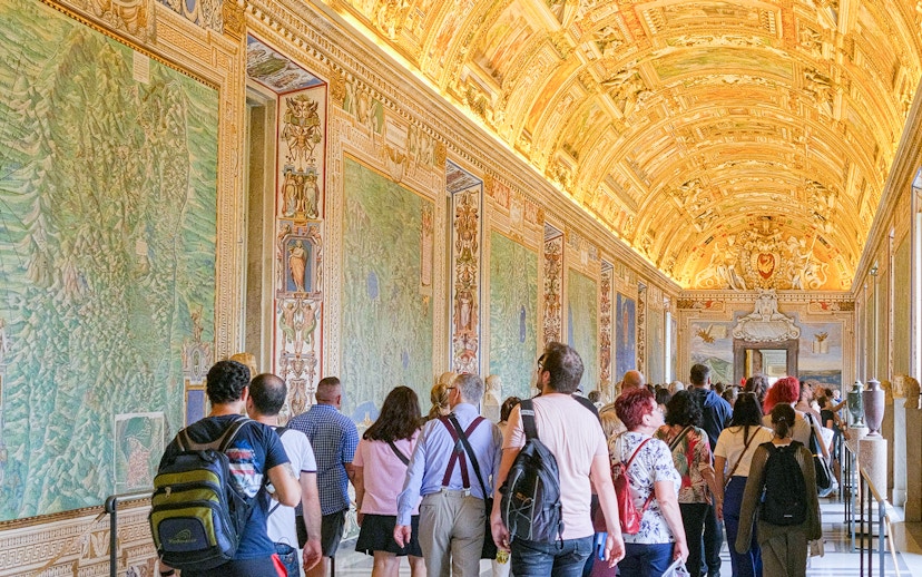 Visitors exploring the ornate Gallery of Maps in the Vatican Museums.