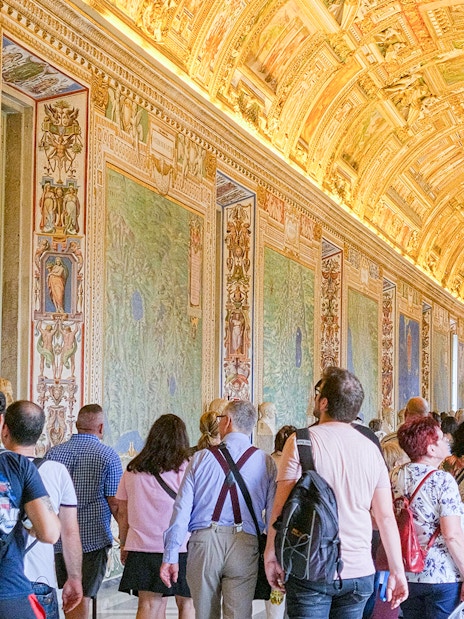 Visitors exploring the ornate Gallery of Maps in the Vatican Museums.