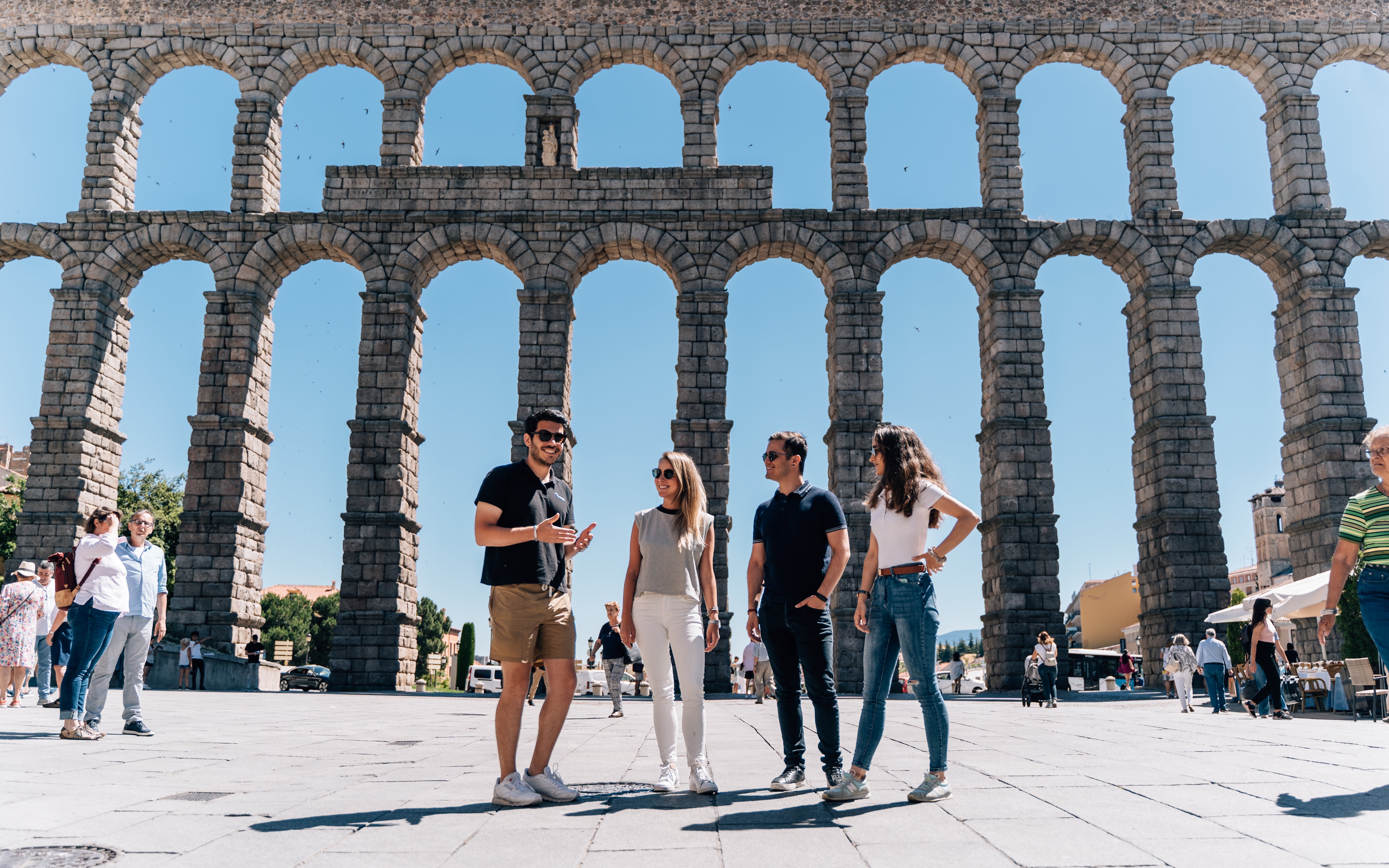 Tourist group with guide at the Aqueduct of Segovia, Spain.