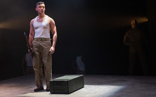 Soldier on stage holding a rifle in "From Here To Eternity – The Musical" performance.