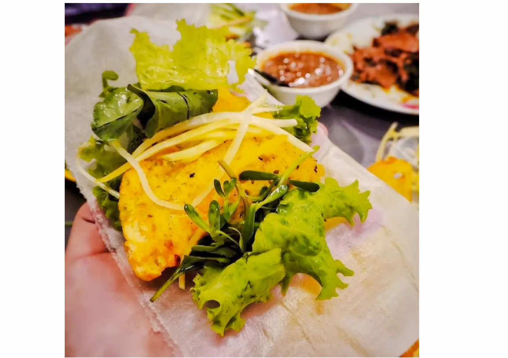 Street food dish with herbs and sauce on Da Nang food tour.