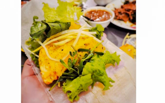 Street food dish with herbs and sauce on Da Nang food tour.