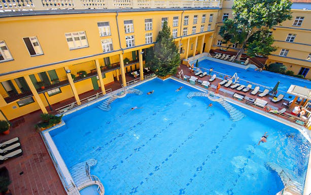 Lukacs Thermal Bath pool with swimmers in Budapest courtyard.