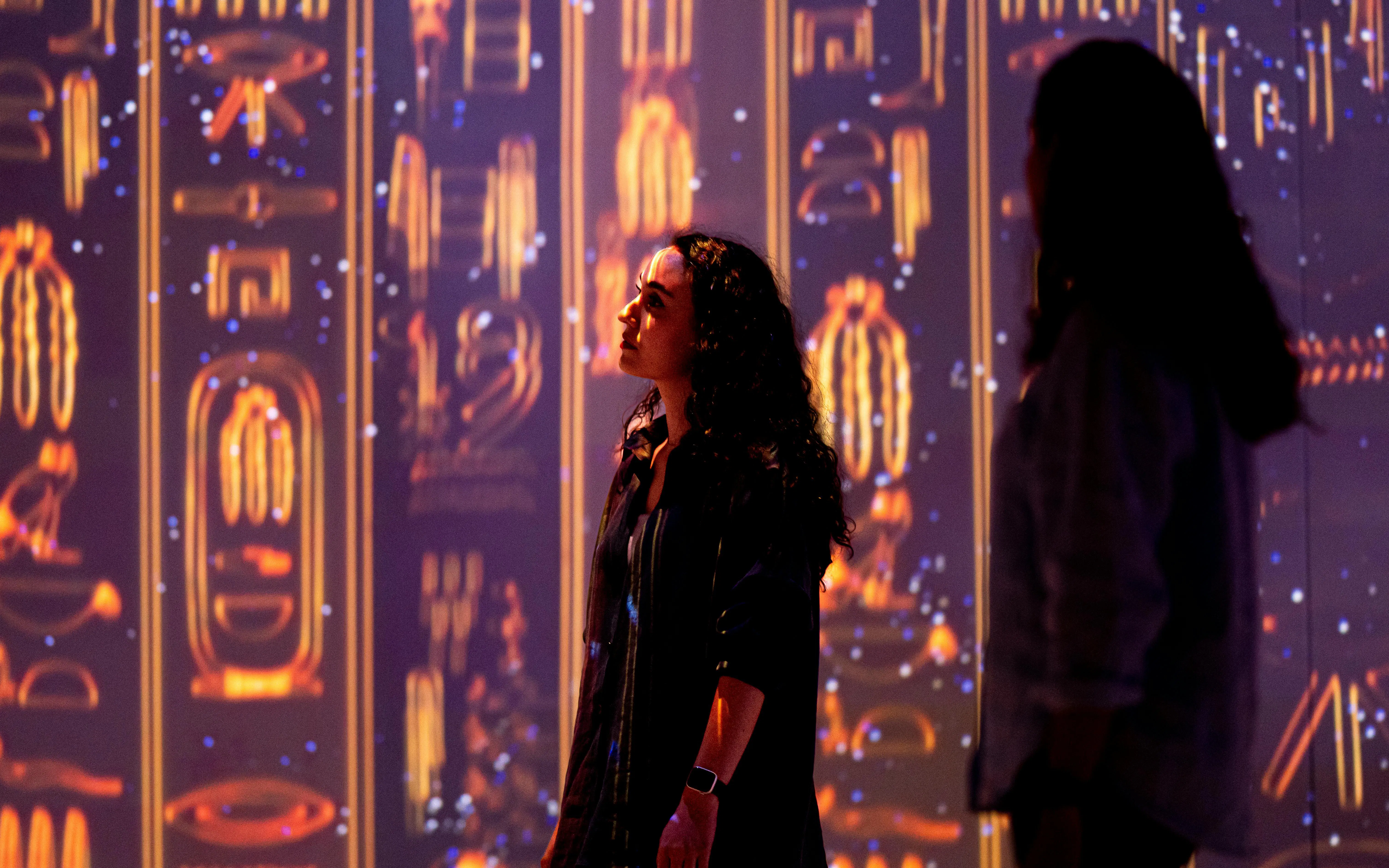 Visitors exploring illuminated hieroglyphs at the London Timewalk Exhibition.