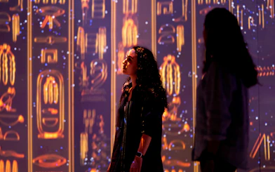 Visitors exploring illuminated hieroglyphs at the London Timewalk Exhibition.