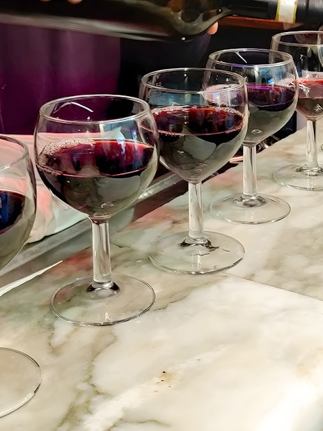 Wine glasses being filled during Florence food tour at All’Antico Vinaio.
