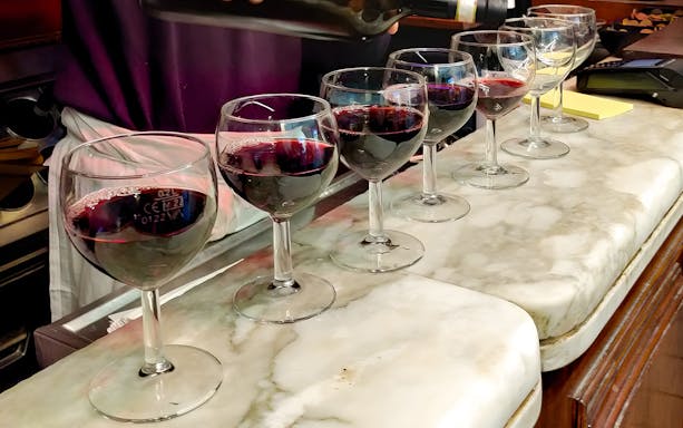 Wine glasses being filled during Florence food tour at All’Antico Vinaio.