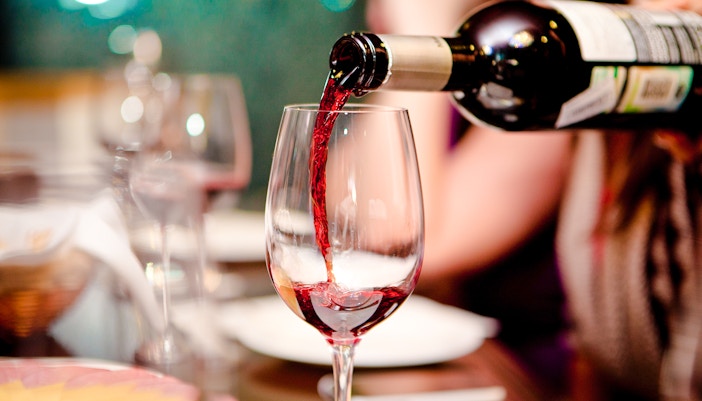 Pouring red wine at Cheese Museum Paris, France.
